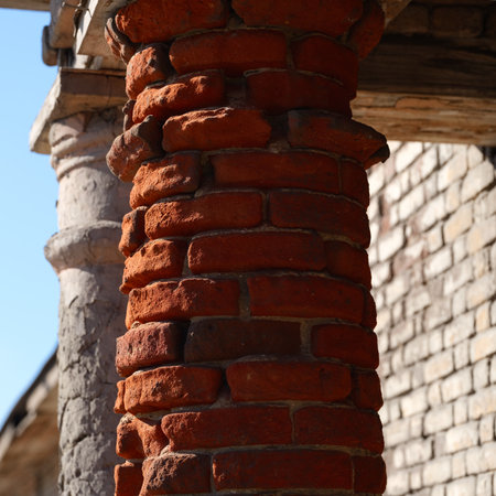 A close-up of old weathered red brick column.の写真素材