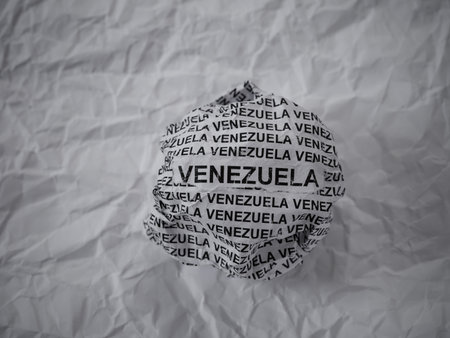 Crumpled paper ball with words Venezuela on a crumpled white paper background.の写真素材