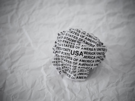 Crumpled paper ball with words USA (United States of America) on a crumpled white paper background.の写真素材