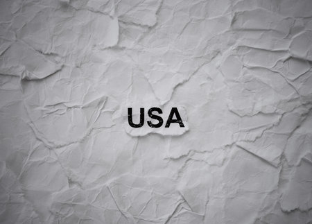 Crumpled piece of paper with word USA on torn crumpled white paper pieces backgroundの写真素材
