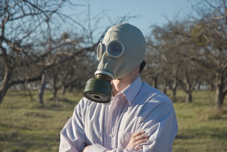 Man in gasmask among old naked treesの写真素材