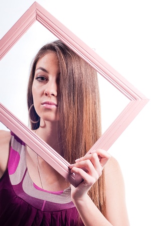 Young beautiful brunette woman with long hair and frame close up studio portraitの写真素材