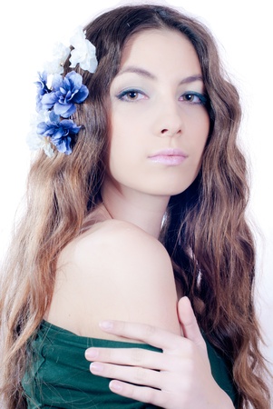 Young beautiful woman with long wavy hair and flowersの写真素材