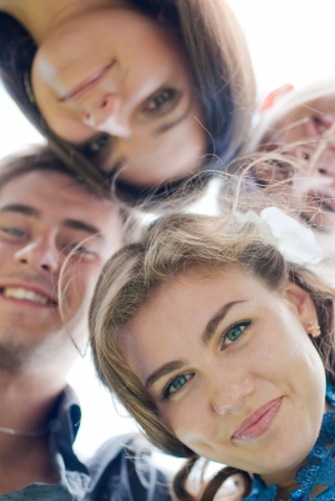 Happy four teenage friends looking downの写真素材