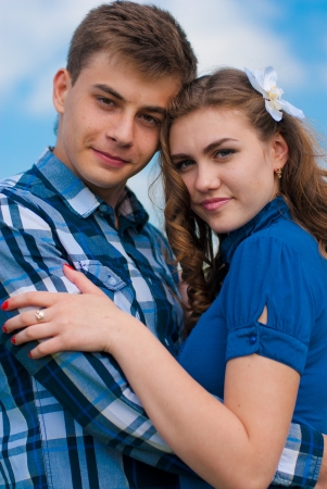 Happy young couple hugging against blue skyの写真素材