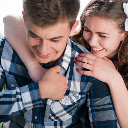 Happy young couple hugging against blue skyの写真素材