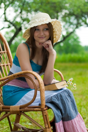 Happy young woman in reading garden chairの写真素材