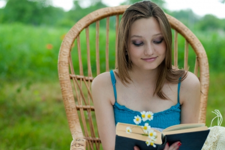 Happy young woman in reading garden chairの写真素材