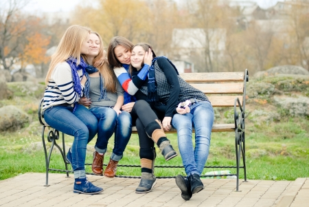 Four happy teen girls friends hugging and having fun outdoorsの写真素材