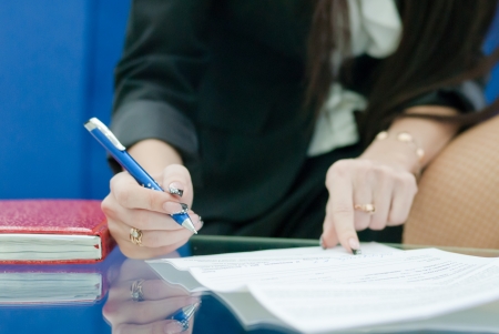 Closeup on business woman handwriting by pen or signing documentsの写真素材