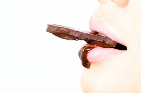 Closeup on chocolate bar melting in woman mouth copyspace isolated on whiteの写真素材