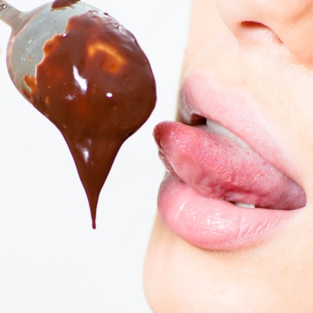 Closeup on tongue licking hot melting chocolateの写真素材