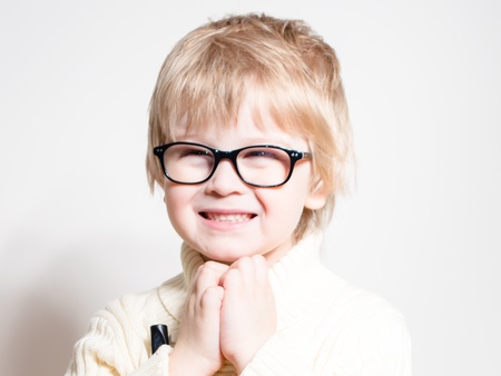 Little boy wearing glasses and smiling happy over white studio backgroundの写真素材
