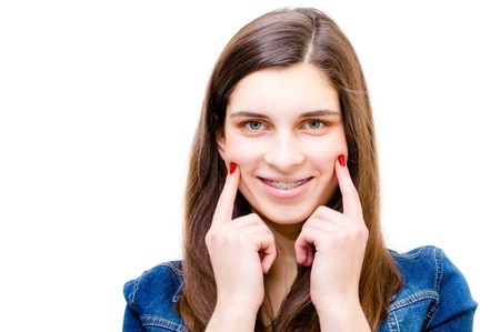Happy teenage girl wearing braces funny smiling isolated over white background