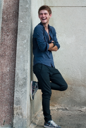 Happy young stylish man laughing outdoorsの写真素材