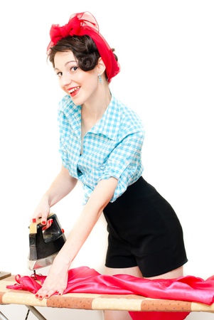 Funny beautiful pinup woman ironing silk dress isolated on white backgroundの写真素材