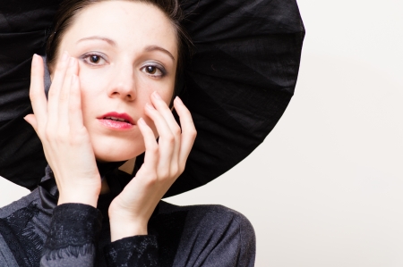 Young beautiful woman in retro victorian dress crying and wiping tears from her faceの写真素材