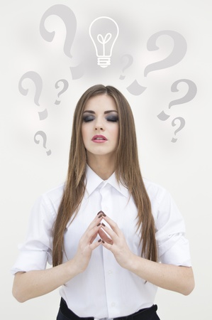 Young beautiful thoughtful business woman looking up on white backgroundの写真素材