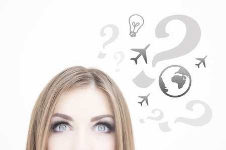 Young thoughtful business woman looking up at ideas sign   symbols on white background