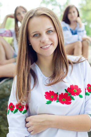 Outdoors portrait of beautiful young teenage brunette girl and her friendsの写真素材