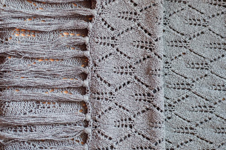 closeup detail of woven handicraft knit woolen design texture. Fabric gray background