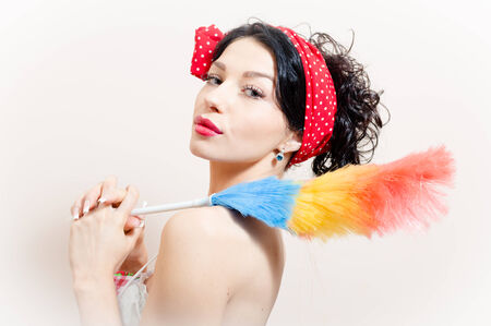 Gorgeous pretty funny young black-haired pinup woman removing dustの写真素材