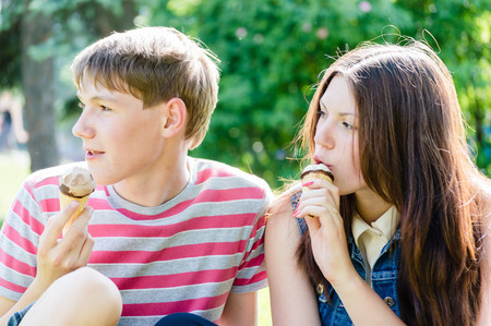 young woman & handsome boy eating ice creamの写真素材