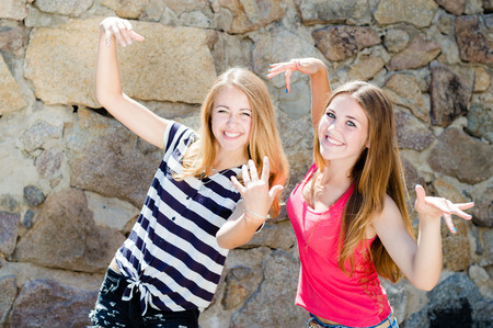 2 funny girls having fun posing grimacingの写真素材