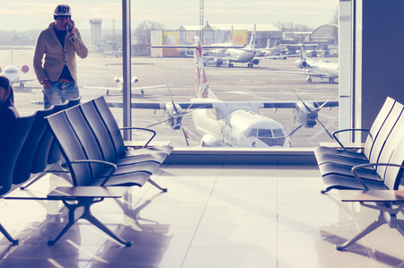 Filtered image of empty lobby of airport with window view on airplanesのeditorial素材