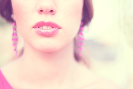 Closeup image of pink plump female lips and earringsの写真素材