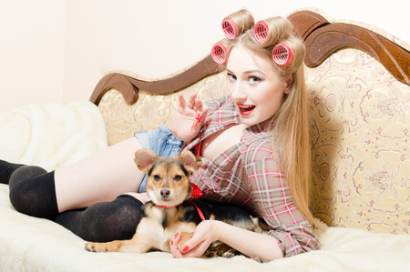 Young sexy playful woman having joyful time relaxing lying in bed with her cute dogの写真素材