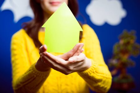 Girl in yellow sweater with arrow in her handsの写真素材