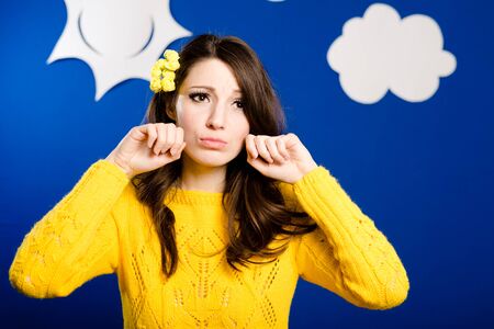 Girl in yellow sweater making cry signs