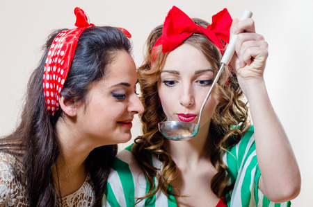 Two happy beautiful young pinup women with ladleの写真素材