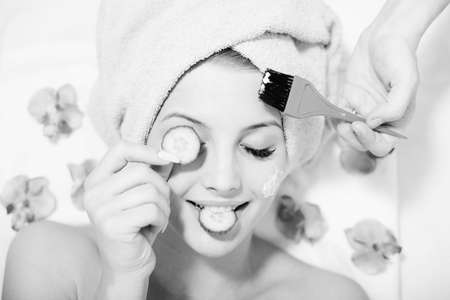 black and white closeup image of funny girl beautiful blond young woman having multi treatment procedures happy smiling eyes closed on white backgroundの写真素材