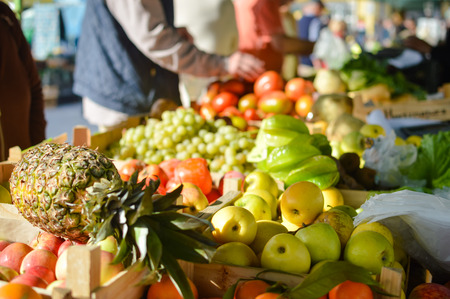 Closeup on person hand shopping for fresh food. Sale, consumerism concept and pineapple with fruits on grocery market stall background.の写真素材