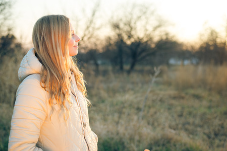 Portrait of a young woman looking with blond hair. Shot outdoors in a cold day with outdoors...