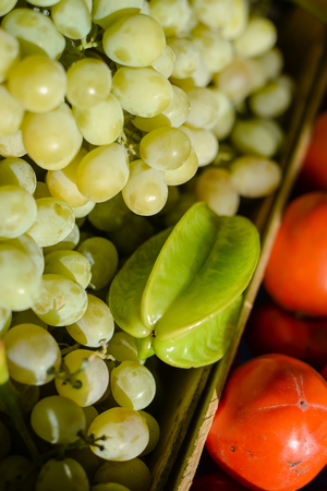 Closeup on pile of grapes, carambola and  sold at fruit marketの写真素材
