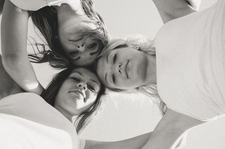 Three happy teen girls looking down on summer day black and white picturerの写真素材