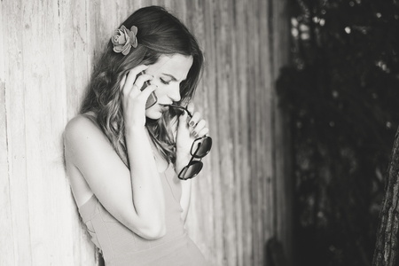 Side view portrait of one attractive woman using talking on mobile phone. Smart sommunication concept on outdoors backgroundの写真素材