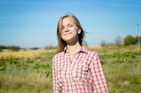Positive attractive blonde girl on outdoors background, portraitの写真素材