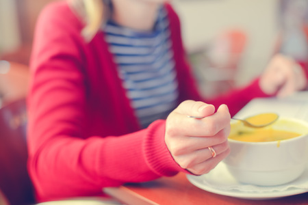 Closeup on busy professional woman typing document on laptop pc computer in cafe. Businessperson using information electronic communication. Eating while browsing mobile wifi internetの写真素材