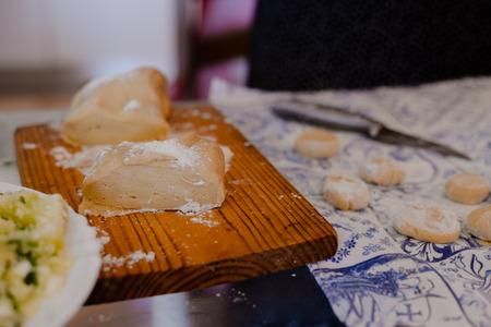 Close up view of making traditional dumplings on kitchen table background