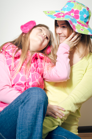Happy cheerful attractive family wearing winter clothing and bright summer hat ready for season travel fun lifestyle. Close up portrait of joyful hugging people with healthy smile on light backgroundの写真素材
