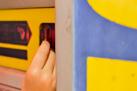 Close up on hand inserting coin into the machine, time for playing, gaming, buying food or drink. Having fun childhood joyful activity macro backgroundの写真素材