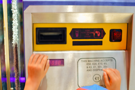 Close up on hand inserting banknote into the machine, time for playing, gaming, buying food or...