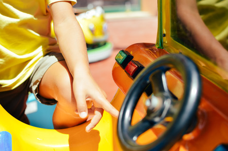 Closeup on children's machine steering wheel on the amusement leisure park backgroundの写真素材