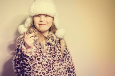 Joyful exciting girl ready for cold winter time on a light background, closeup portrait. Youth, love, happiness and excitementの写真素材