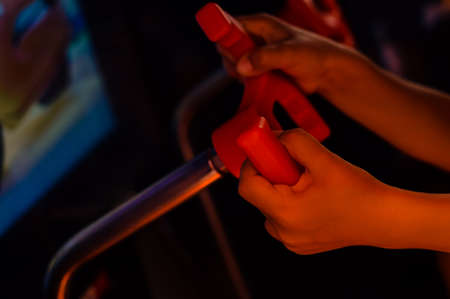 Close up on kid hands playing behind the wheel of a game console background. Electronic business...