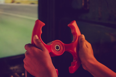 Close up on kid hands playing behind the wheel of a game console background. Electronic business entertainment activity. Playful education simulation technologyの写真素材
